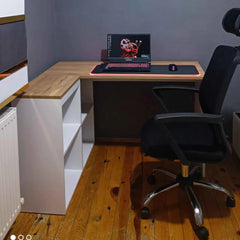 Home office setup with a desk, chair, and shelves against a gray wall.