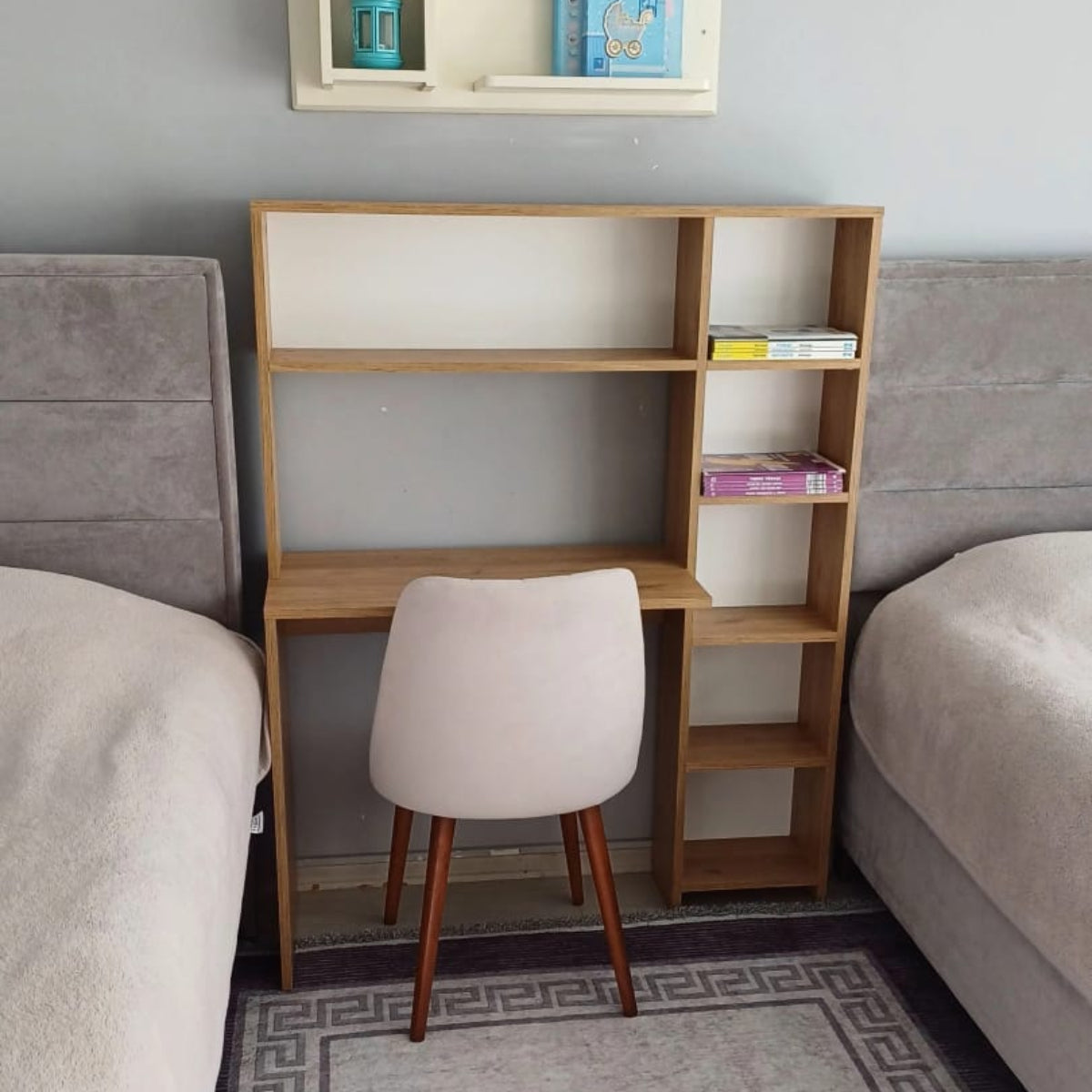 Small wooden bookshelf with a chair against a gray wall with a shelf above.
