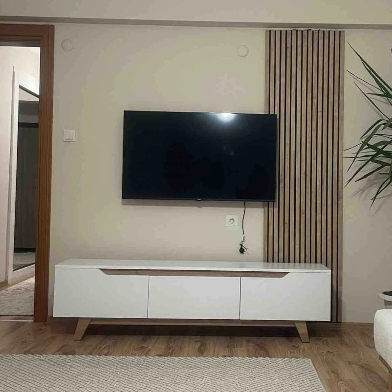 Living room with a TV on a stand, sofa, and decorative elements.