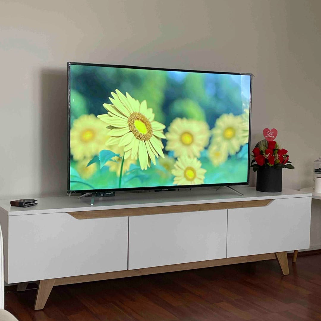TV on a white entertainment console with a flower display