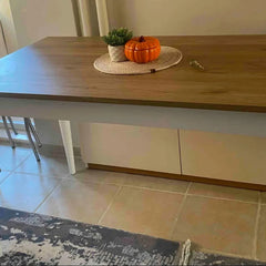 Wooden table with decorative items on a tiled floor