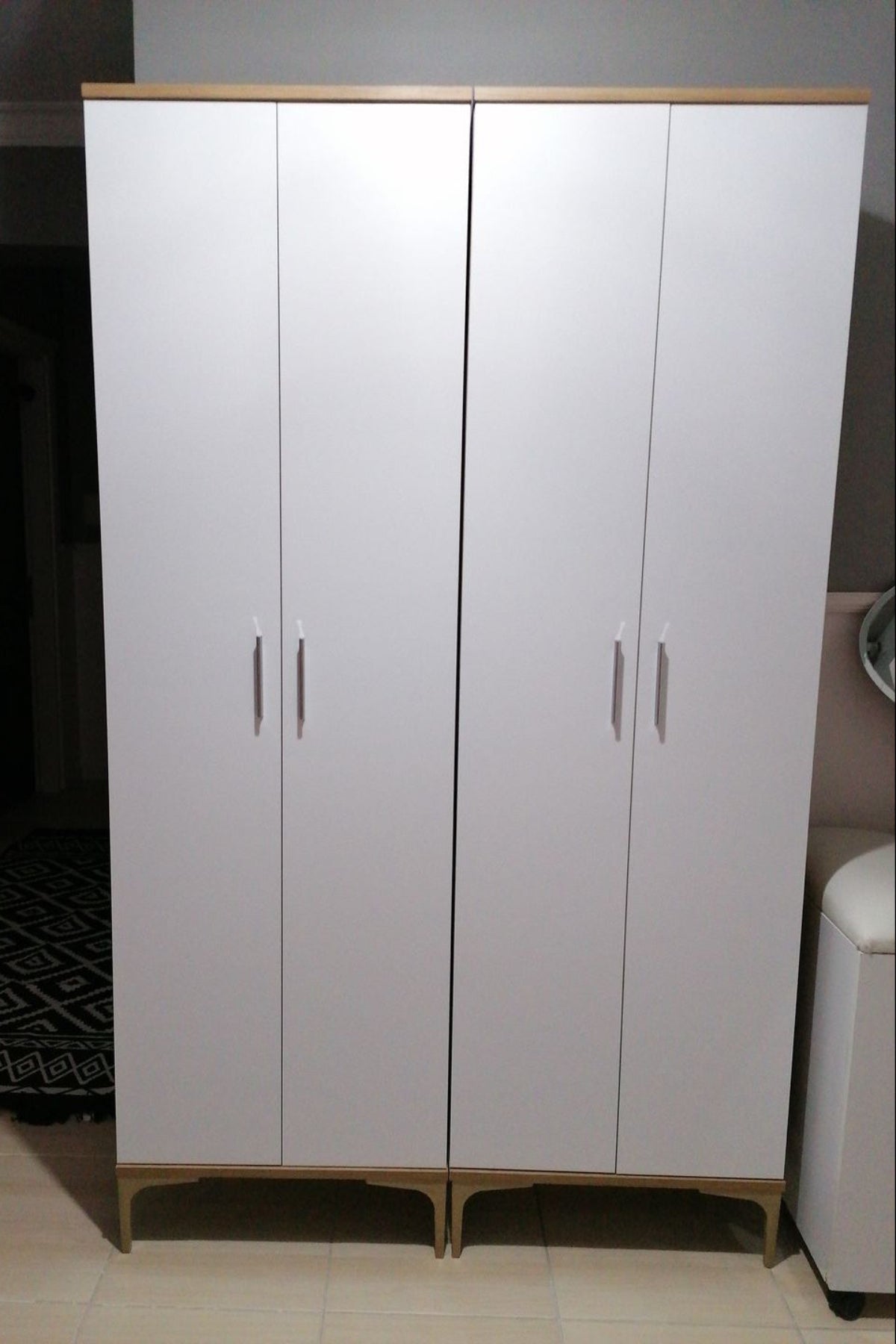 White wardrobe with wooden top and legs in a room setting