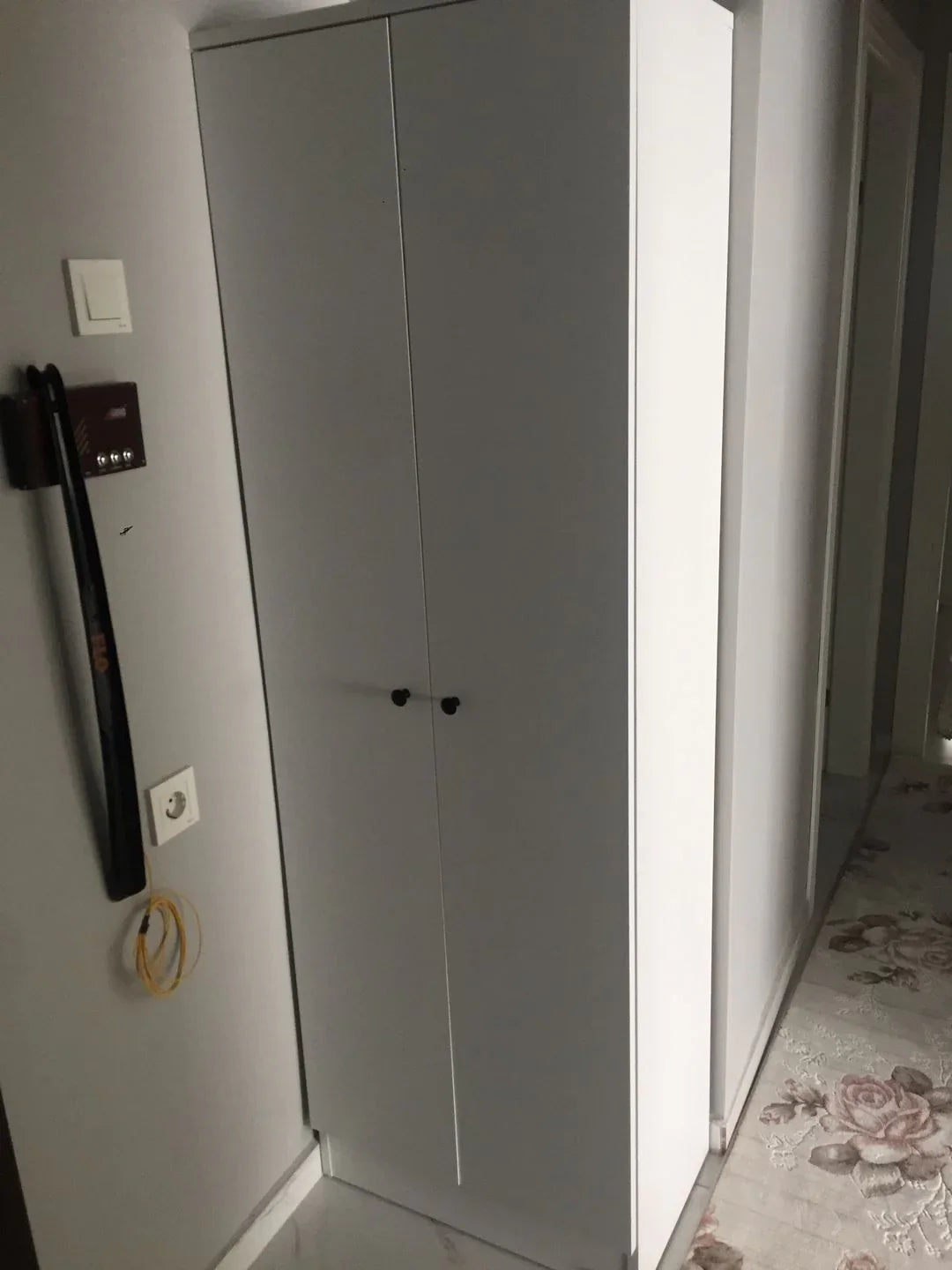 White wardrobe with a floral-patterned rug on the floor