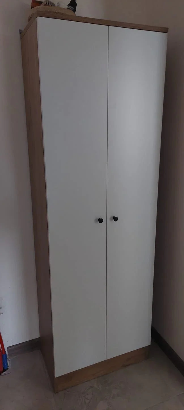 White wardrobe with wooden base and top corner in a room.