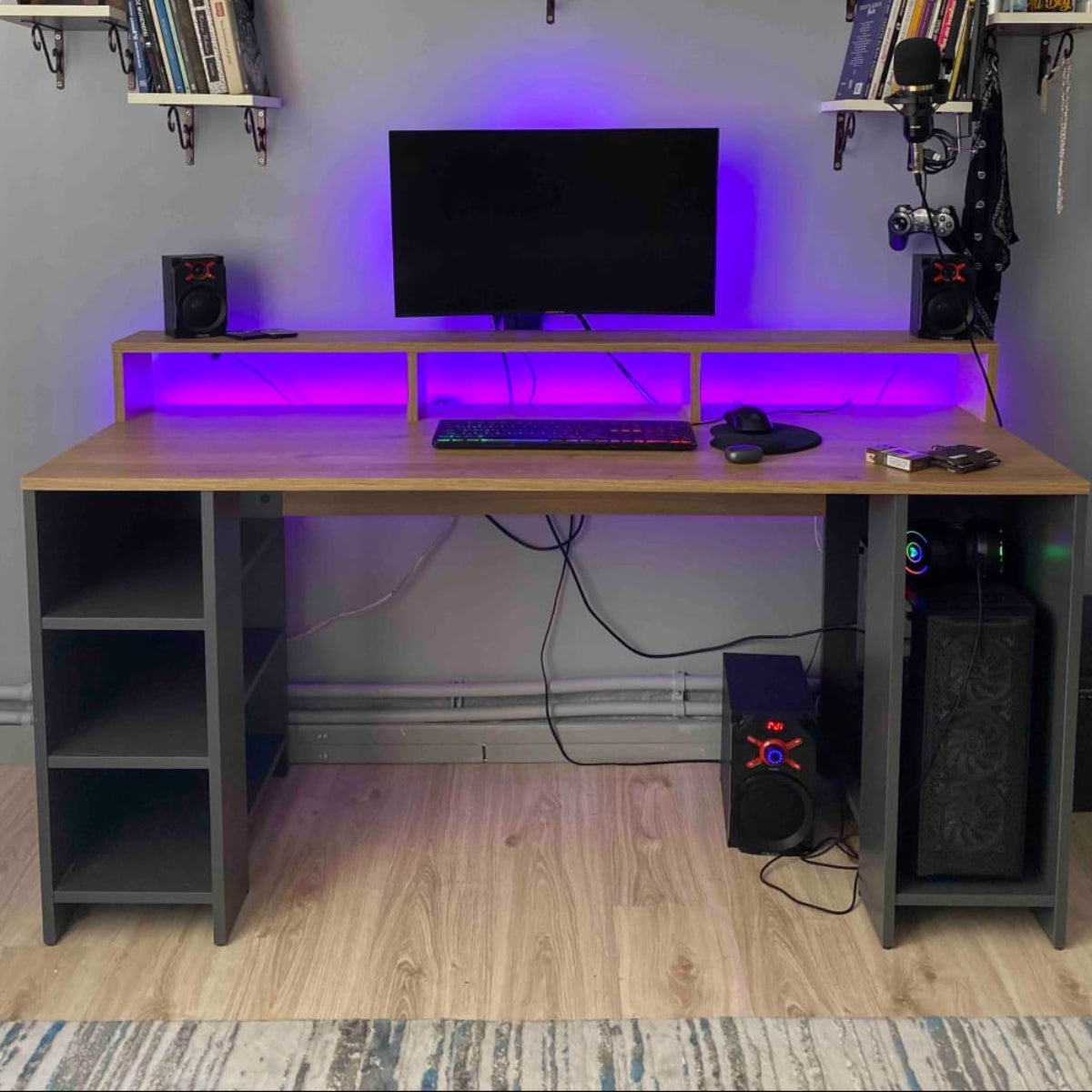Modern home office setup with a desk, computer equipment, and wall-mounted shelves.