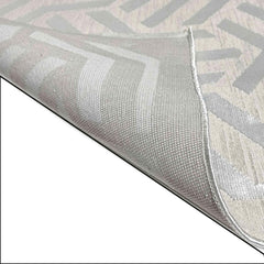 Close-up of a textured gray and white rug with geometric pattern