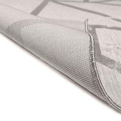 Close-up of a textured gray rug with geometric patterns on a white background