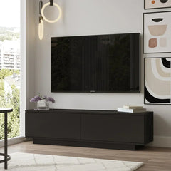 Modern living room with a black TV stand, television, and decorative items.