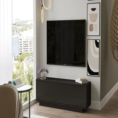 Modern living room with a television mounted on the wall, a black cabinet, and abstract art.