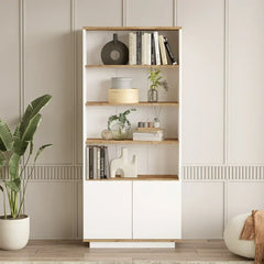 Wooden bookshelf with books and decor items against a light wall.