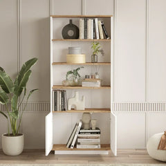 Bookshelf with books and decor items in a room with a plant and white wall.