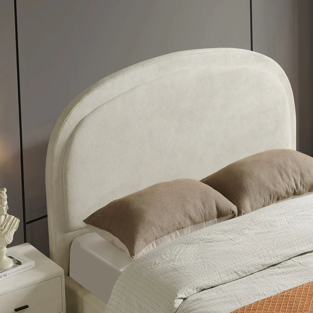Beige upholstered headboard with brown pillows on a bed against a gray wall.