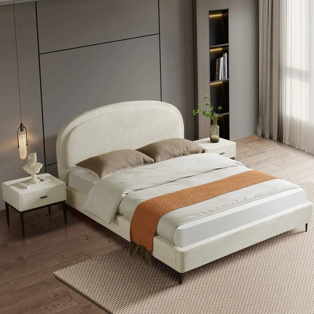 Modern bedroom with a white upholstered bed, nightstands, and decor elements.