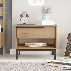 Wooden nightstand with books, alarm clock, and plant in a modern bedroom setting.