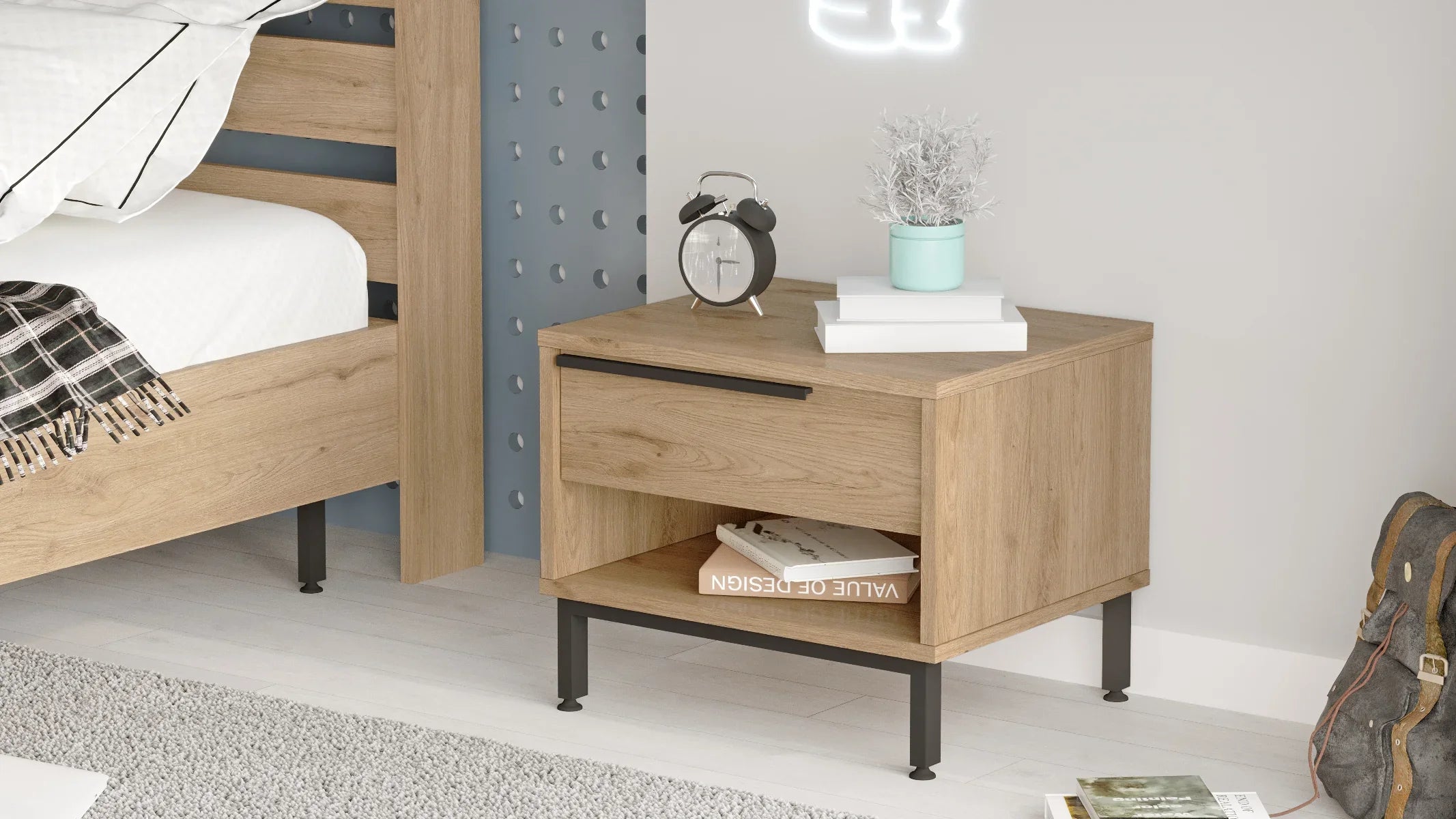 Wooden nightstand with books and alarm clock in a bedroom setting
