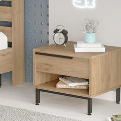 Wooden nightstand with books and alarm clock in a bedroom setting