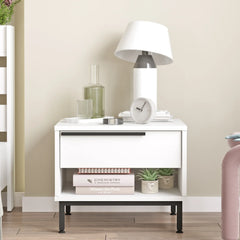White nightstand with books, a lamp, and decor items against a beige wall.