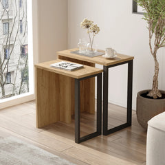 Two wooden side tables with metal legs in a room with a window and plant.