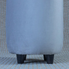 Close-up of a gray upholstered chair on a textured surface
