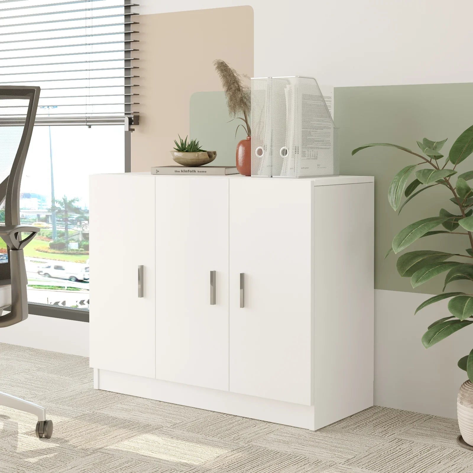 White storage cabinet in an office setting with a plant and chair visible.
