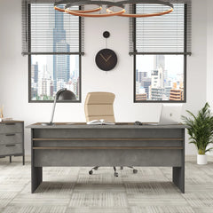 Modern office desk with chair, lamp, and computer in a room with large windows and cityscape view.
